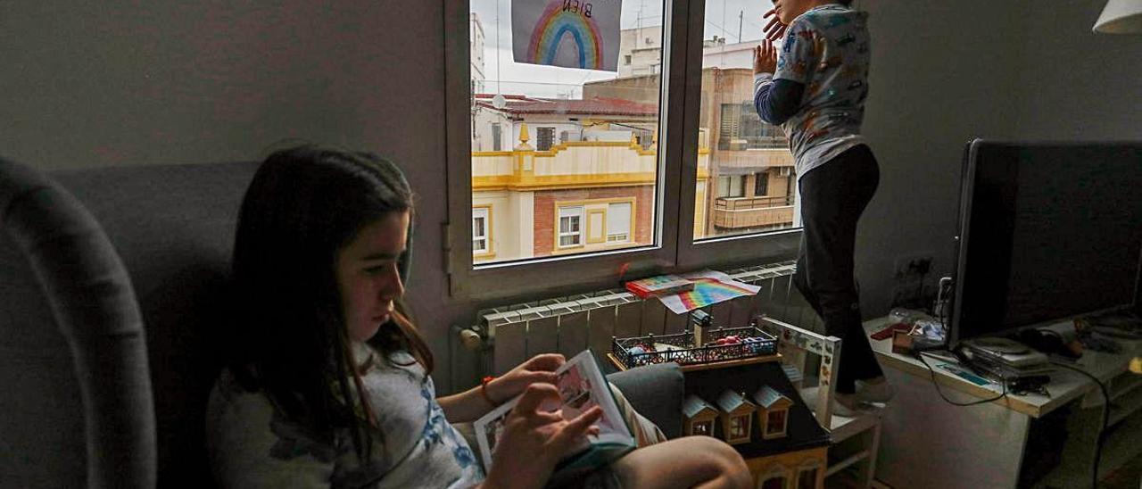 Dos niños confinados en su casa a la espera de salir a la calle a partir del domingo.