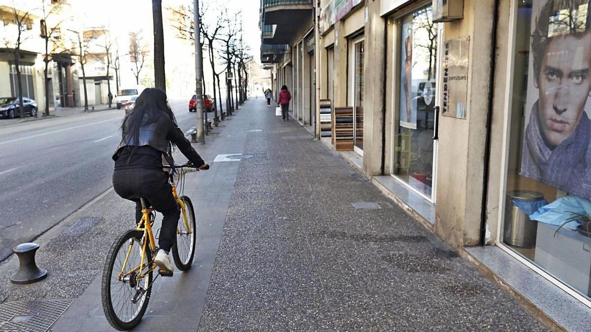 Una bicicleta passant per sobre d&#039;uns panots que podrien ser un carril bici, però no ho són.