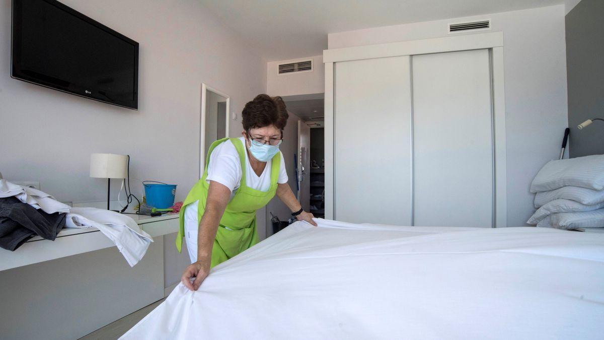 Una señora hace la cama en un establecimiento hostelero.
