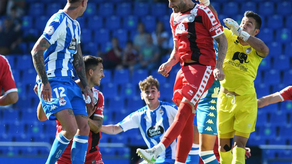 Borja Granero salta de cabeza mientras el portero visitante, Salva de la Cruz, intenta despejar el balón. | @PRIMERA_RFEF