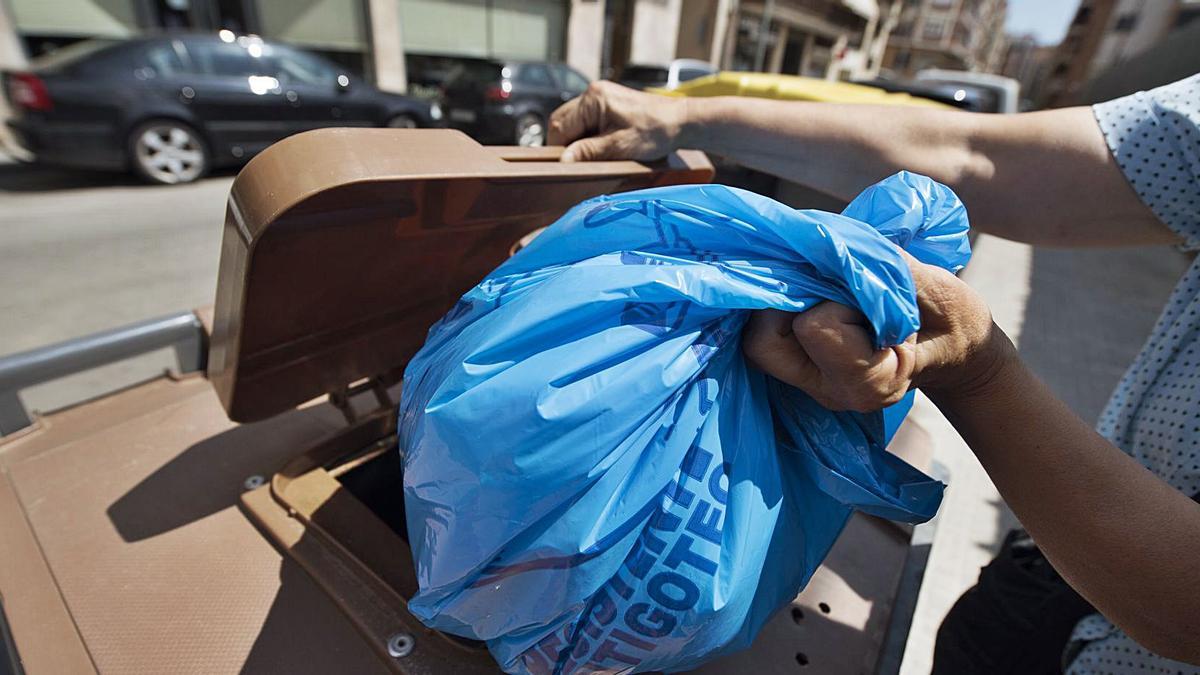 Una persona fotografiada utilitzant un contenidor marró d’orgànica a Manresa