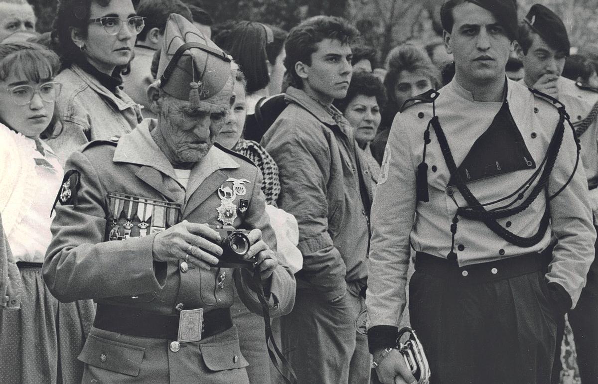 Un fotógrafo legionario prepara su cámara para captar la salida de la cofradía de San Francisco.