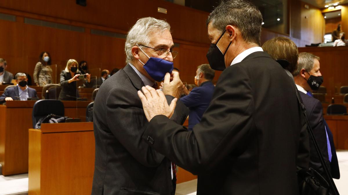 El consejero de Agricultura y Medio Ambiente, Joaquín Olona, con el diputado del PP Antonio Romero, este jueves en el pleno de las Cortes.