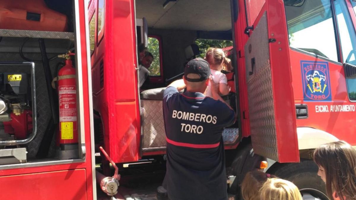 Los bomberos enseñan su camión a los niños en el día de san Lorenzo del año 2018. | I. A.