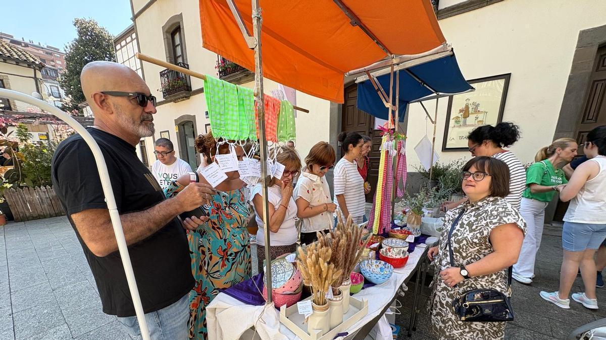 Compradores en el mercadillo de la cooperativa Artepenlés.