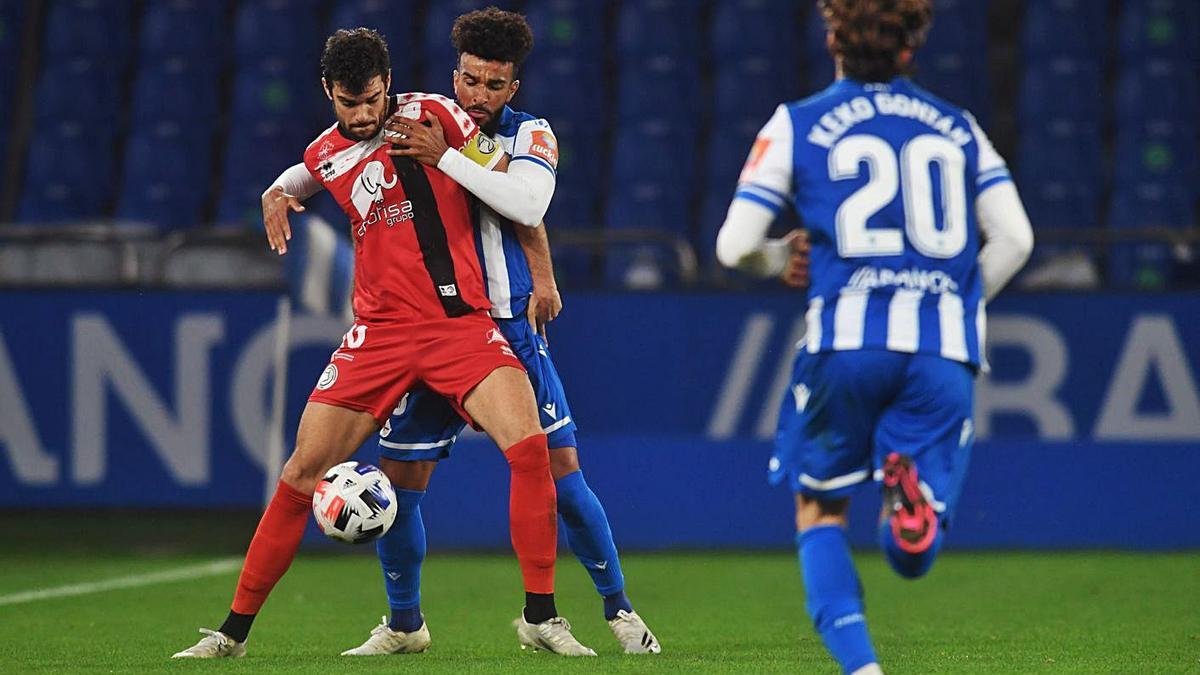 Un jugador del Unionistas protege el balón ante la presión de un rival del Deportivo. |  // CARLOS PARDELLA