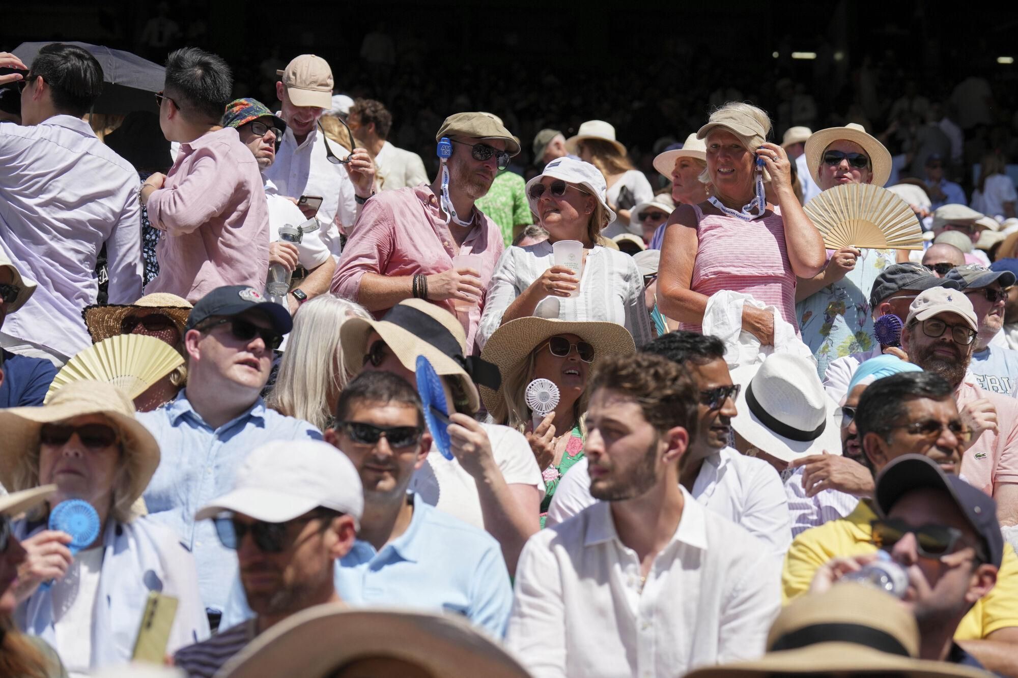 The crowd swelter as Taylor Fritz of the U.S. plays Spain's Carlos Alcaraz in a men's singles semifinal at the Wimbledon Tennis Championships in London, Friday, July 11, 2025. (AP Photo/Kin Cheung). EDITORIAL USE ONLY/ONLY ITALY AND SPAIN
