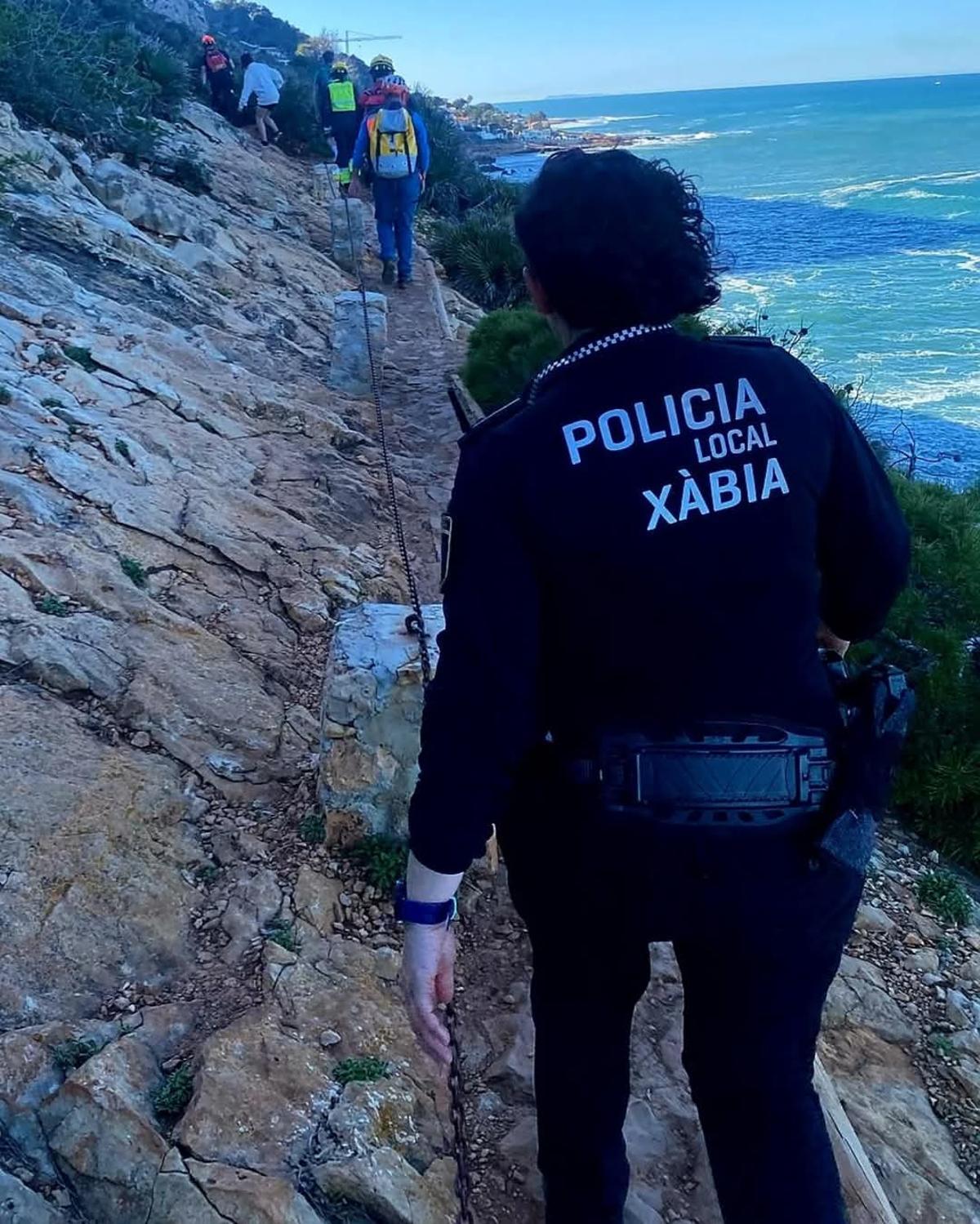 Los agentes y efectivos de emergencia acompañan a los jóvenes por la senda que lleva a les Rotes de Dénia