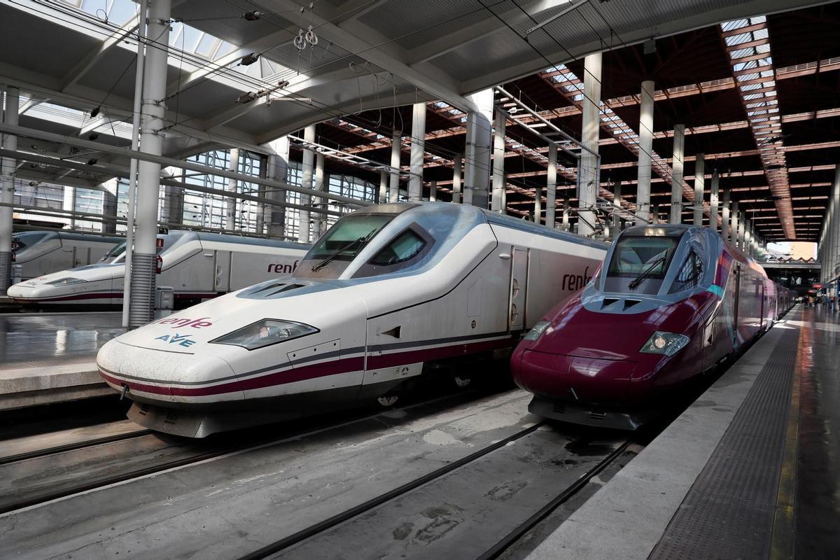 Vista de un tren AVE (i) junto al tren (d) del servicio de alta velocidad de bajo coste Avlo, de Renfe, en la estación de Madrid Atocha. 