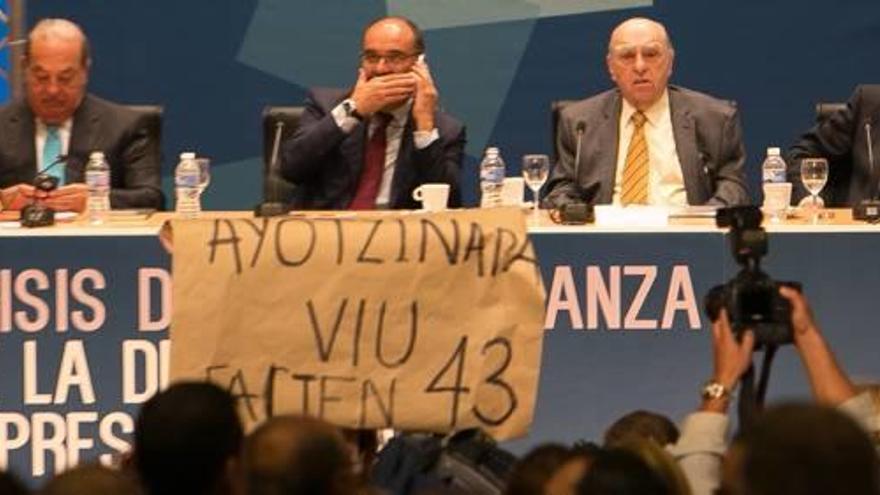 Los ponentes del Círculo de Montevideo, ayer, con el rector hablando por el móvil, durante la irrupción de los estudiantes que trataron de boicotear el acto.