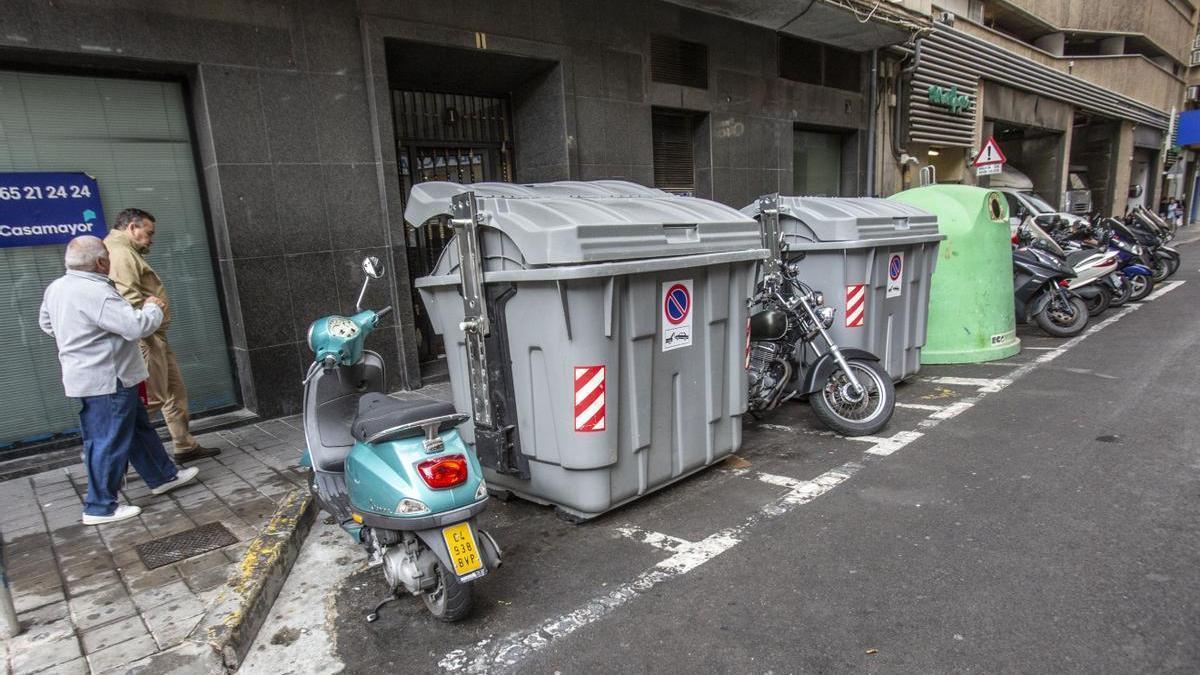 Contenedores de basura y vidrio ocupando plazas exclusivas para motos, en una calle próxima a Federico Soto