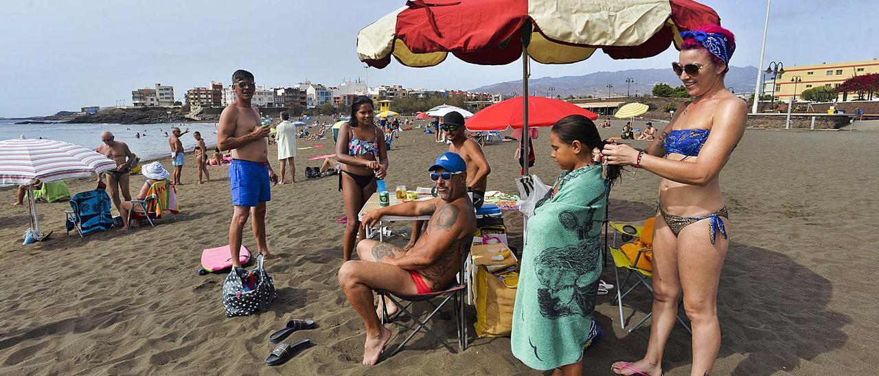 Una familia en la playa teldense de Melenara  | | ANDRÉS CRUZ