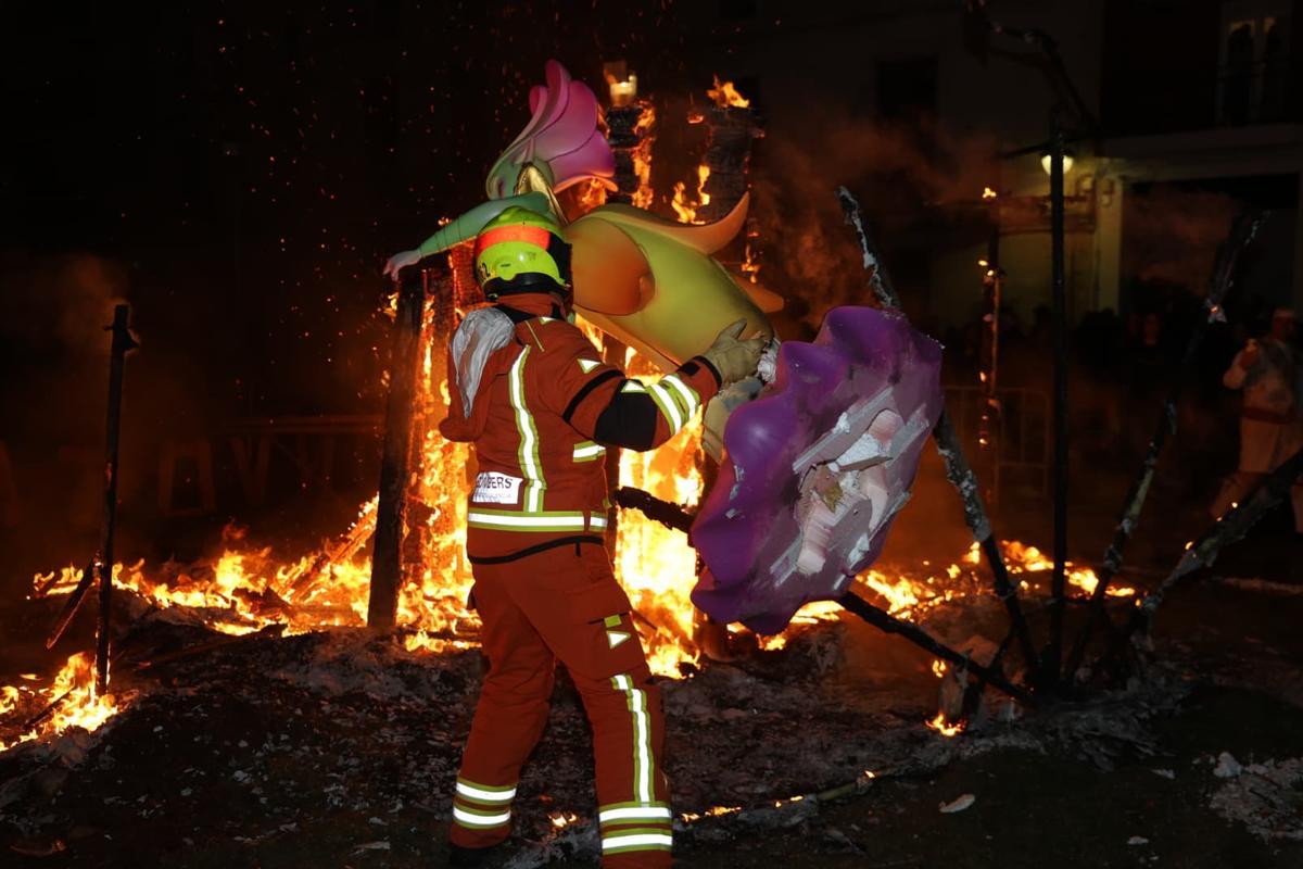 Un bombero ayuda en las tareas de quema de la falla Sant Jaume.