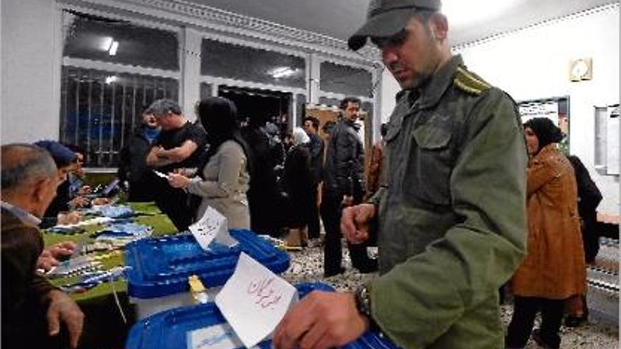 Un policia iranià, exercint el seu dret a vot durant les eleccions del passat divendres.