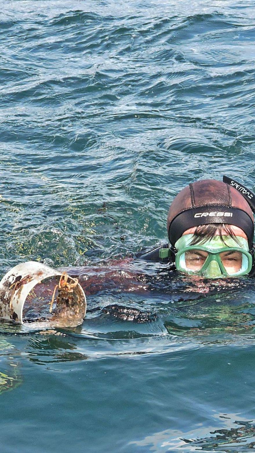 Uno de los submarinistas extrae una vieja nasa. 