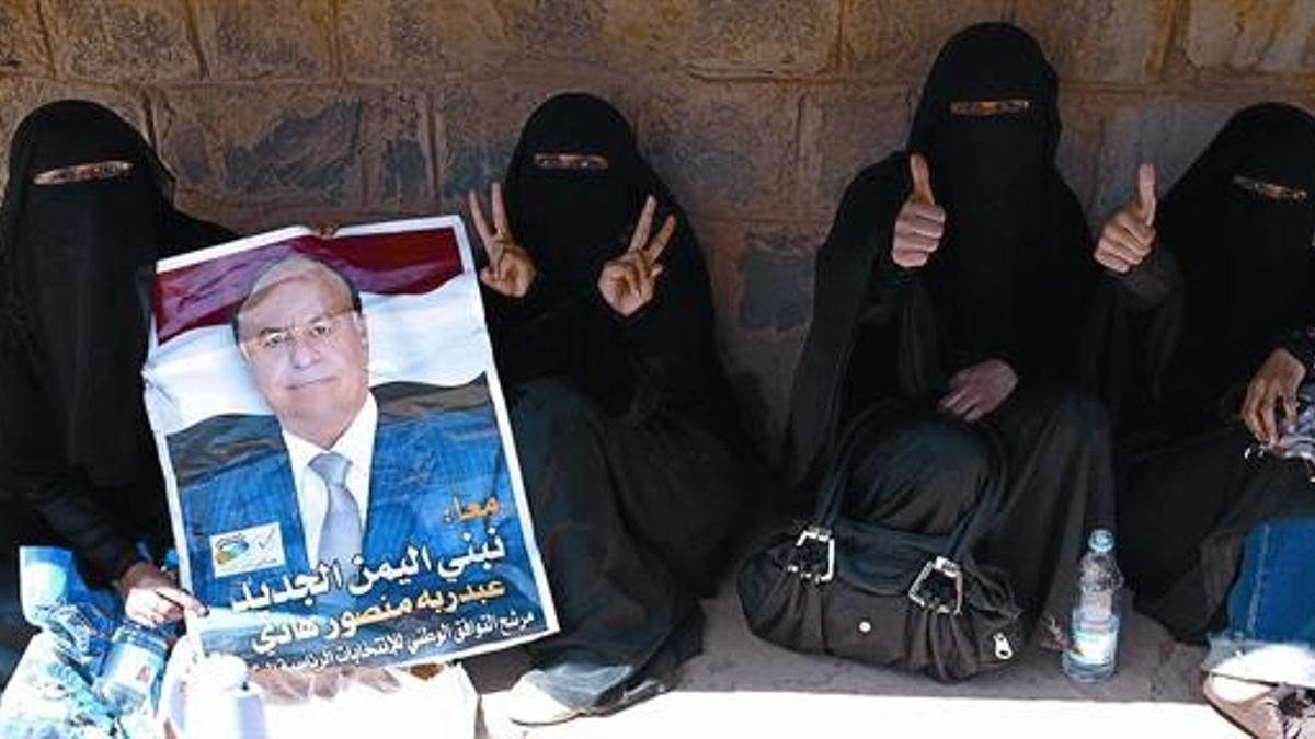 Mujeres yemenís con un cartel electoral del vicepresidente y candidato único Abdrabbo Mansur Hadi, en Saná, ayer.