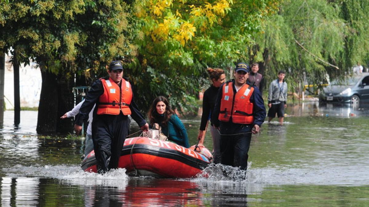 Efectivos socorren a varios damnificados por las inundaciones en la ciudad bonaerense de La Plata, ayer.