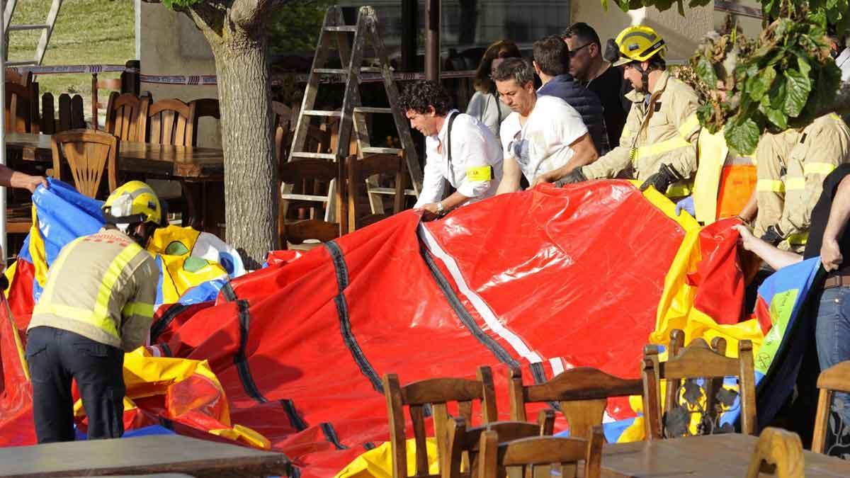 Operarios y bomberos retiran el castillo hinchable del restaurante Mas Oller, en Caldes de Malavella, tras el accidente sucedido en el 2017