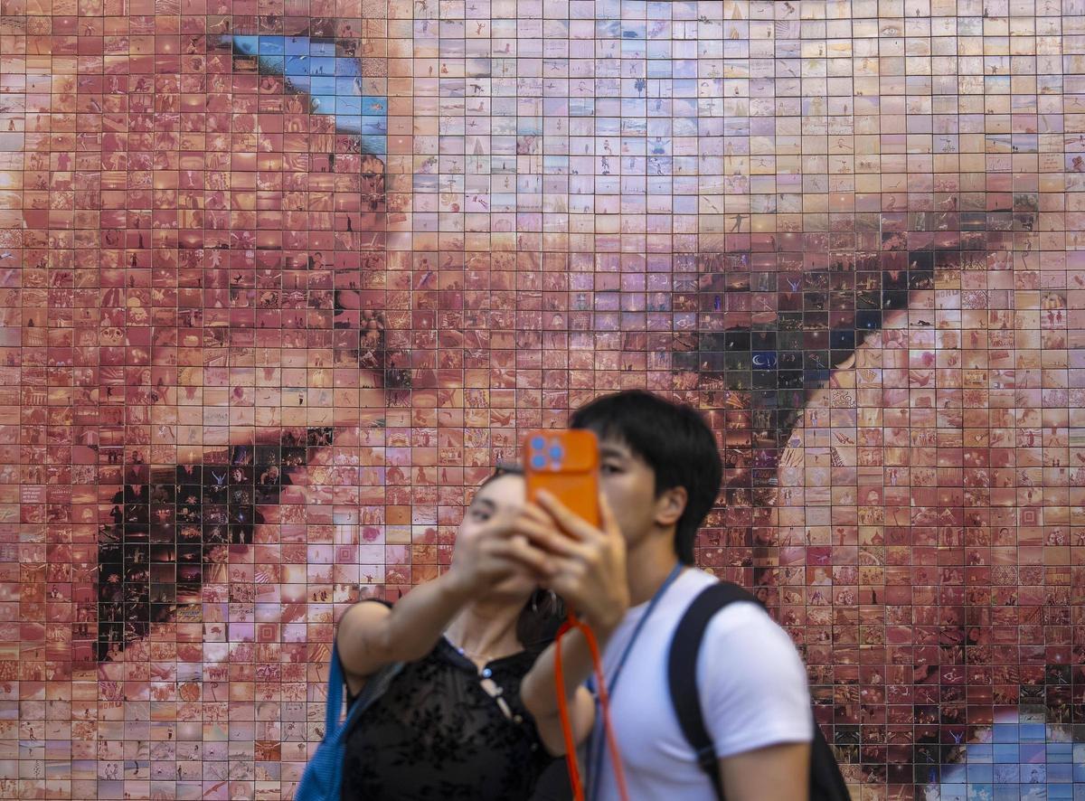 Una pareja se fotografía delante del mural ‘el mundo nace en cada beso’, de Joan Fontcuberta, en la plaza de Isidre Nonell, para ilustrar el debate sobre el repunte entre los jóvenes de modelos de pareja basados en la fidelidad y la monogamia. Barcelona, 23 de septiembre de 2026.