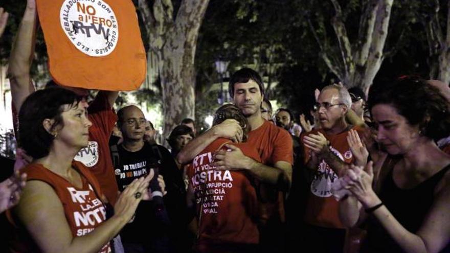 Los trabajadores que protestaban frente a la sede del consejo de administración de Radiotelevisión Valenciana muestran su emoción tras conocerse la aprobación.