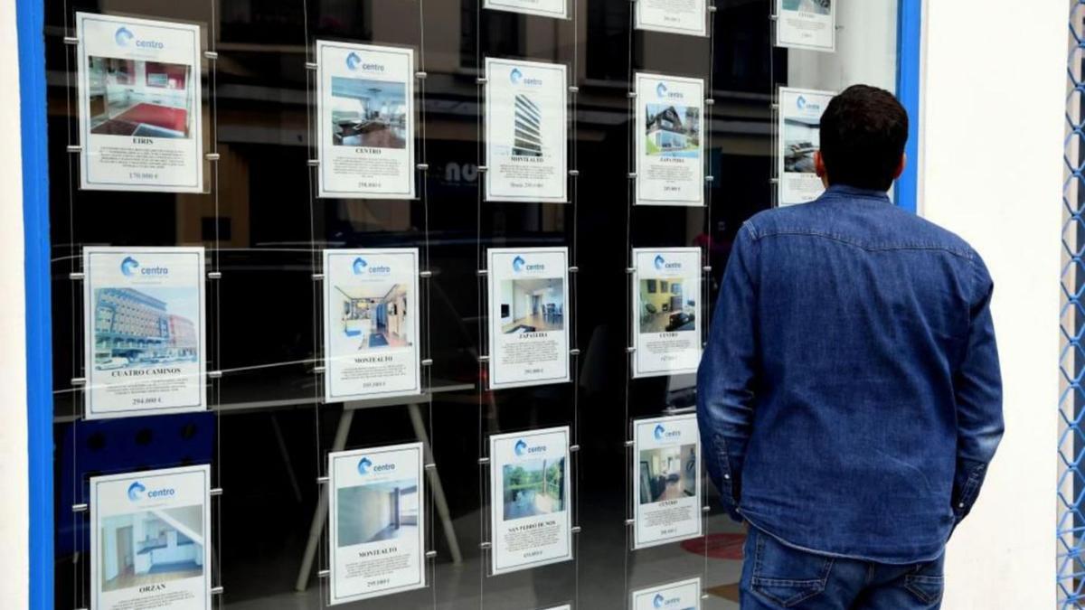 Un joven observa la oferta de pisos en una inmobiliaria de A Coruña.