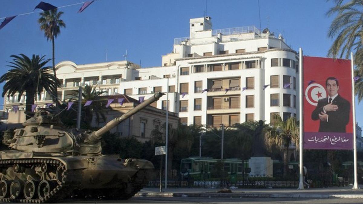 Un tanque y un cartel del huido Ben Alí comparten protagonismo en una de las desérticas calles de la capital tunecina.