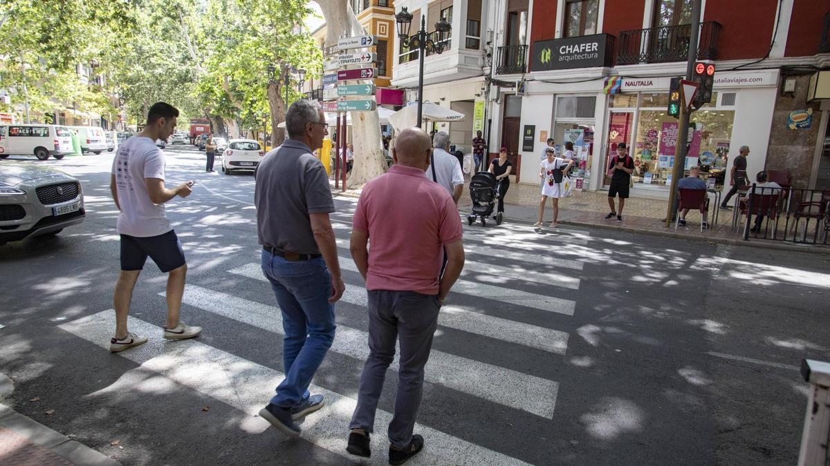 Varias personas cruzan un paso de peatones en la Alameda de Xàtiva.
