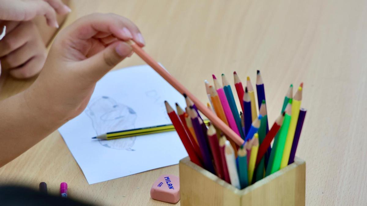 Un niño coge un lápiz de color.