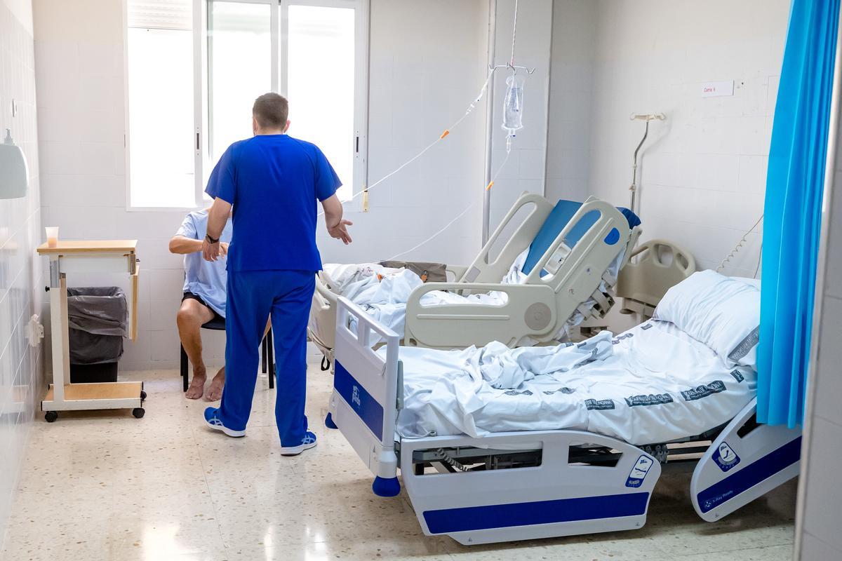 Un sanitario atiende a un paciente en una sala de preingeso.