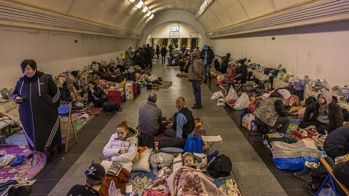 Unas personas permanecen en el interior de la estación de metro de Dorohozhychi, convertida en refugio antibombas, en Kiev.