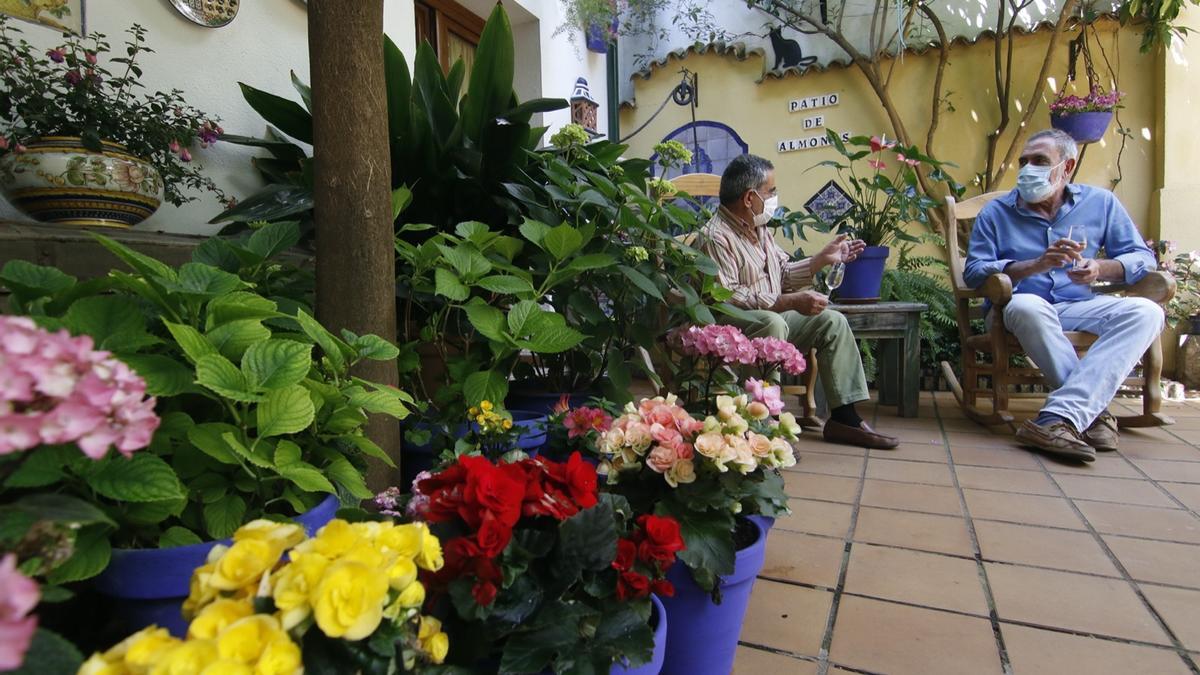 Benito Raya, cuidador de Gutiérrez de los Ríos 33, conversa con un amigo en su patio.