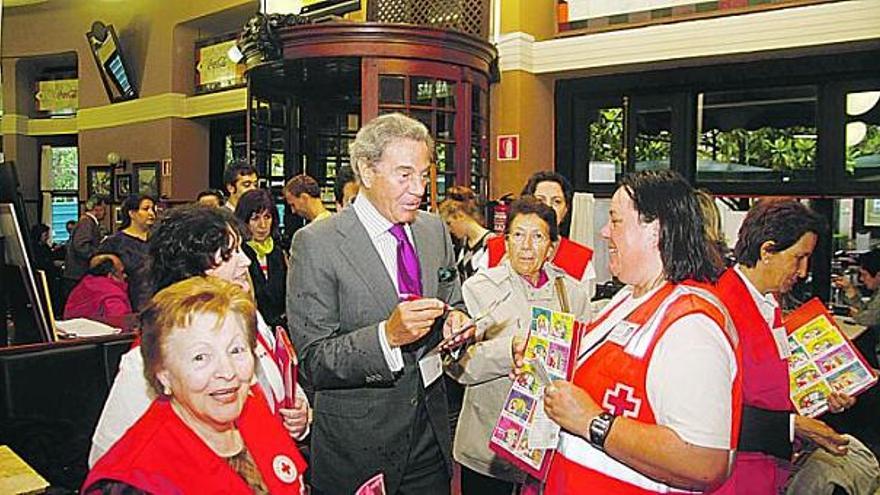 Arturo Fernández, rodeado de fans y vendedoras del sorteo del oro, dispuesto a firmar algunos boletos en el café Dindurra.