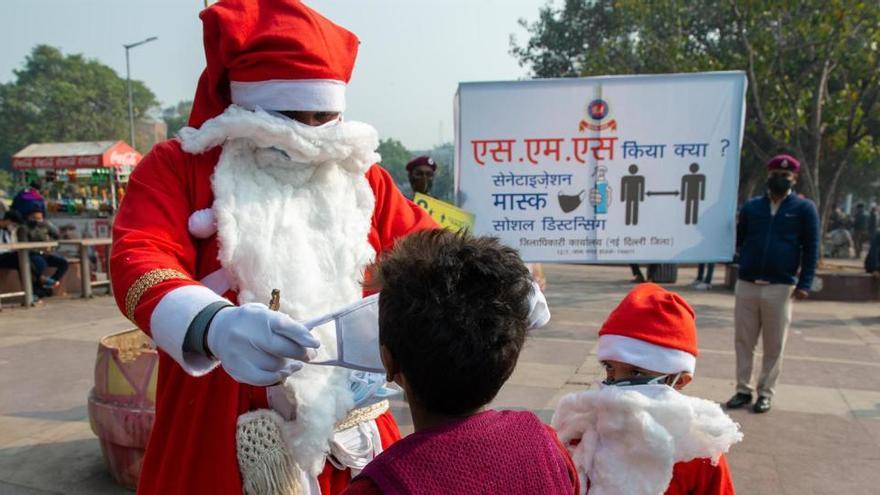 Un hombre reparte mascarillas en Nueva Delhi.