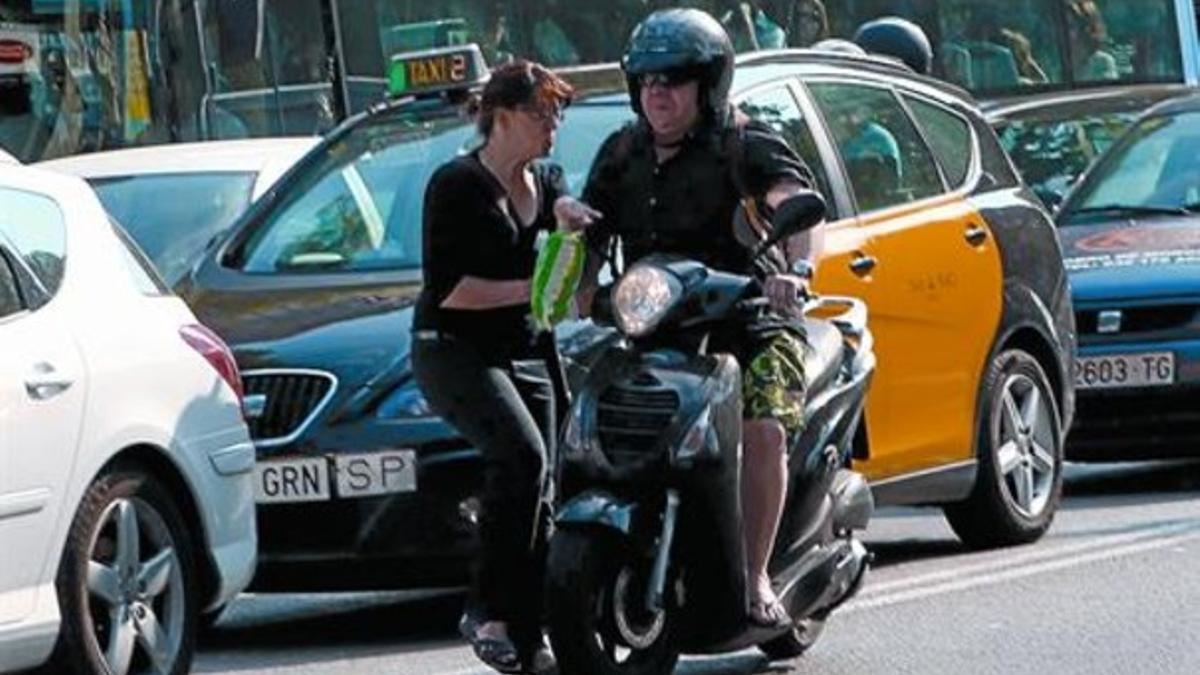 Una moto que va por el carril contrario en la Diagonal casi atropella a una mujer que cruza indebidamente, ayer.