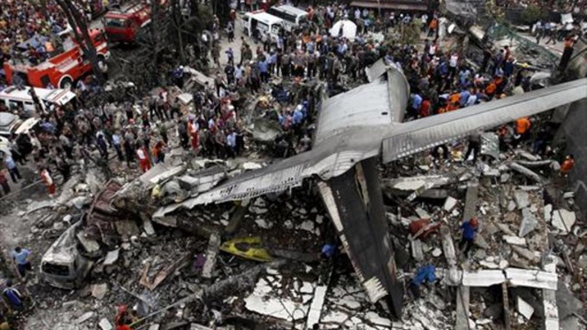 Miembros de los equipos de rescate inspeccionan los restos del avión siniestrado en Medan, en el norte de la isla indonesia de Sumatra, ayer.