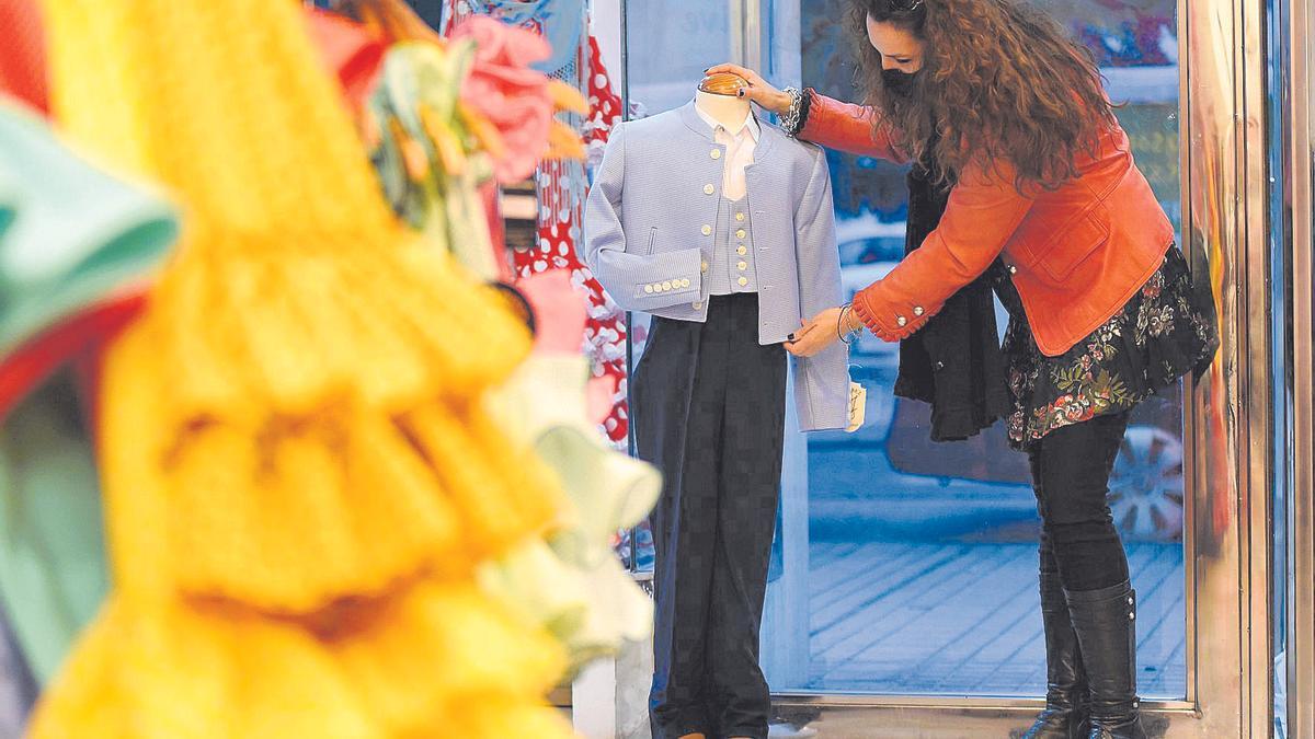 La diseñadora Pepa Serrano coloca un traje de corto en un maniquí, en su tienda de Levante.