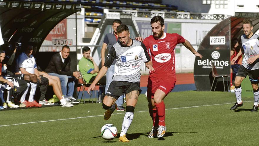 Iván Fernández pugna con Juanín en el encuentro de la primera vuelta.