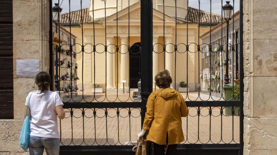 Dues persones a la porta d&#039;un cementiri