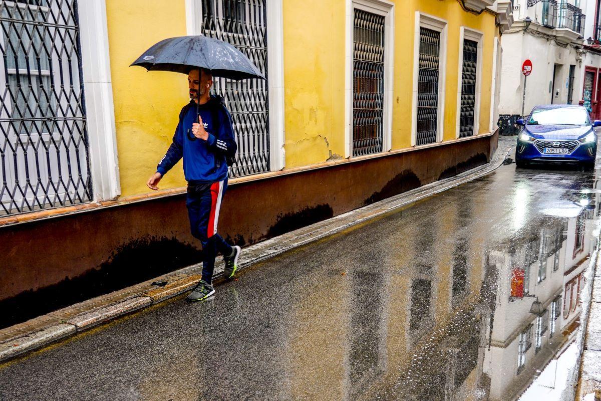 Un ciudadano se protege de la lluvia con un paraguas.