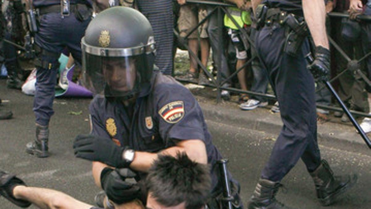 Un policía forcejea con un miembro del colectivo de indignados que se habían concentrado en las proximidades del Congreso de los Diputados.