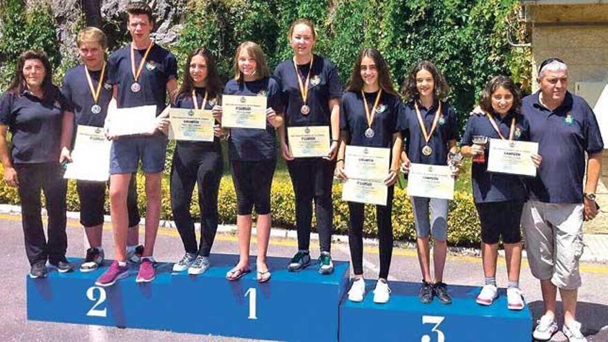 Los deportistas posan en el podio con sus diplomas.