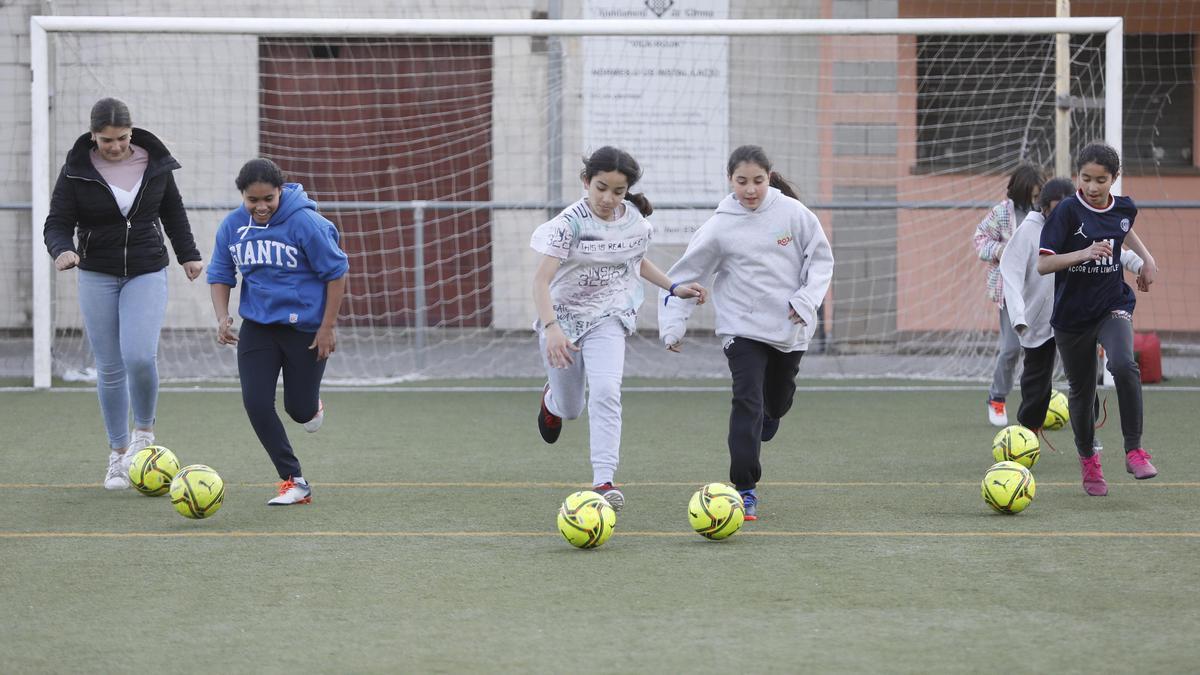 Un grup de nenes corre amb pilotes cedides pel Girona FC, una de les entitats que col·laboren en el projecte.