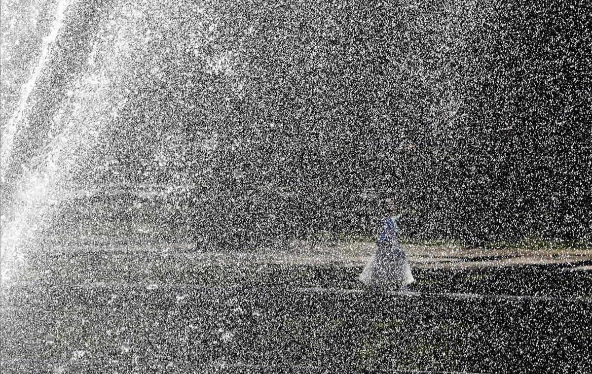 Una niña disfrazada de hada juega junto a una fuente este miércoles en el Parque del Cincuentenario en Bruselas (Bélgica). Los belgas disfrutan estos días de temperaturas de más de 18 grados.