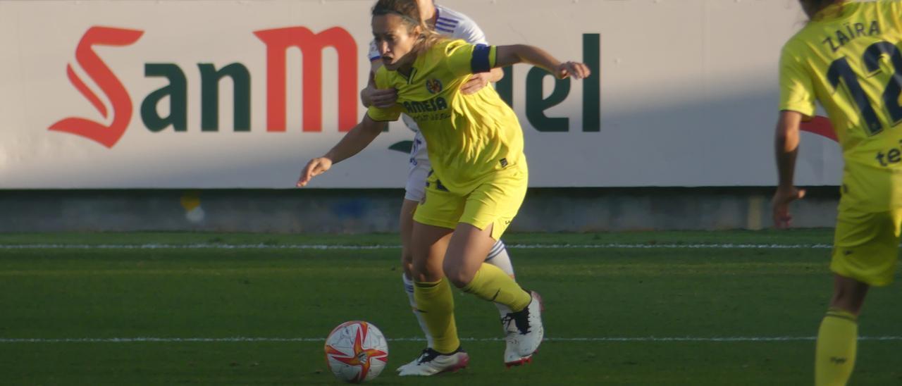 La capitana amarilla Lara Mata conduce un balón ante la asfixiante presión de una delantera del Real Madrid,
