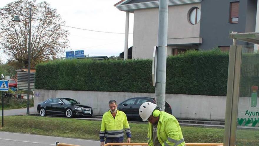 Dos operarios, ayer, realizando las labores para instalar una cámara en la avenida de Viella de Lugones.