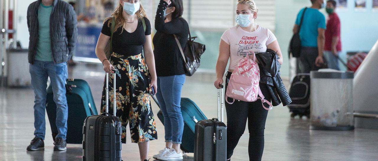 Turistas con mascarillas de protección en el aeropuerto de Alicante-Elche