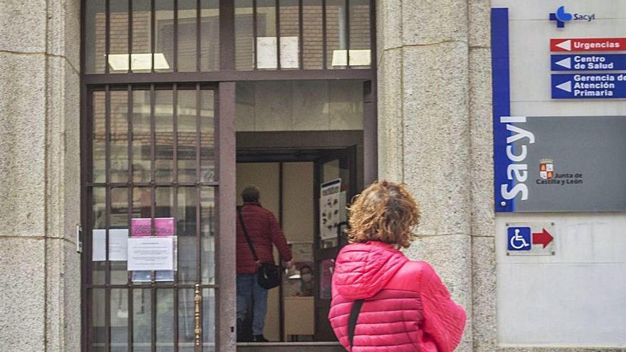 Un mujer observa el centro de salud Benavente Sur desde el exterior.