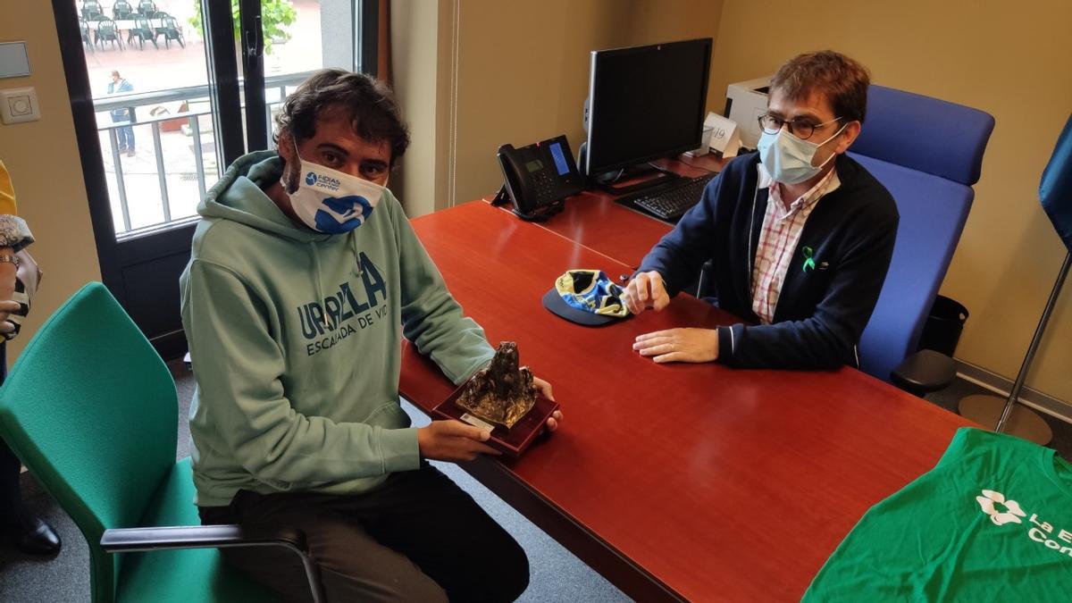 Miguel Ángel Roldán recibe de manos del alcalde de la localidad asturiana de Cabrales una miniatura del pico que va a escalar.