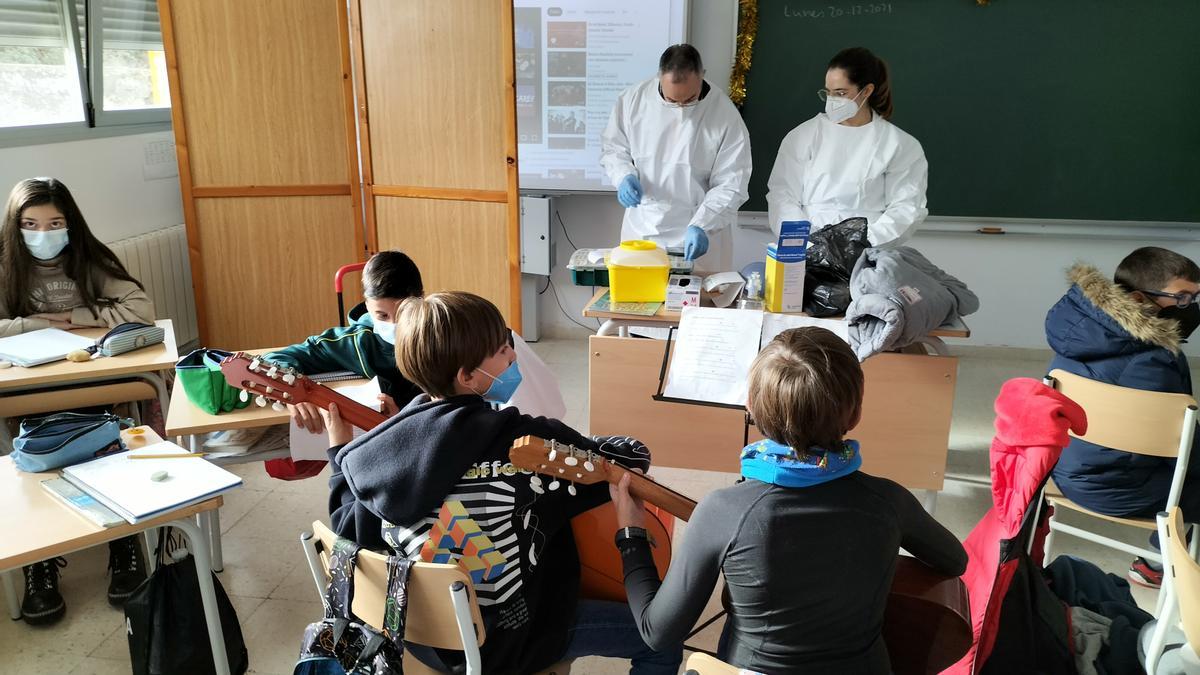 Los niños cantan villancicos mientras los sanitarios preparan las dosis de vacunas