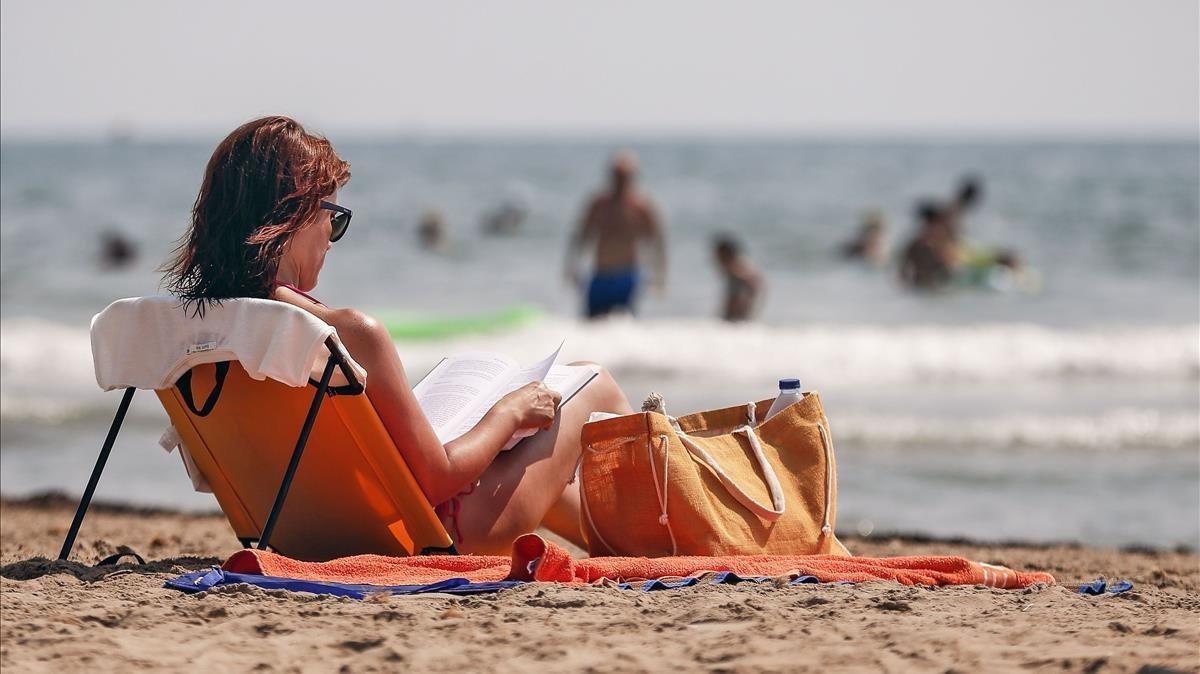 Una mujer leyendo en la playa. 